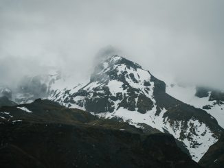 severe snowy mountains under thick clouds